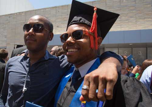 Father puts arm around graduate son 