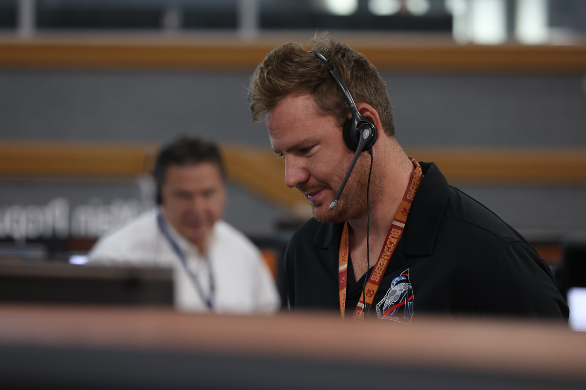 Man with headset on at desk in NASA Firing Room 1