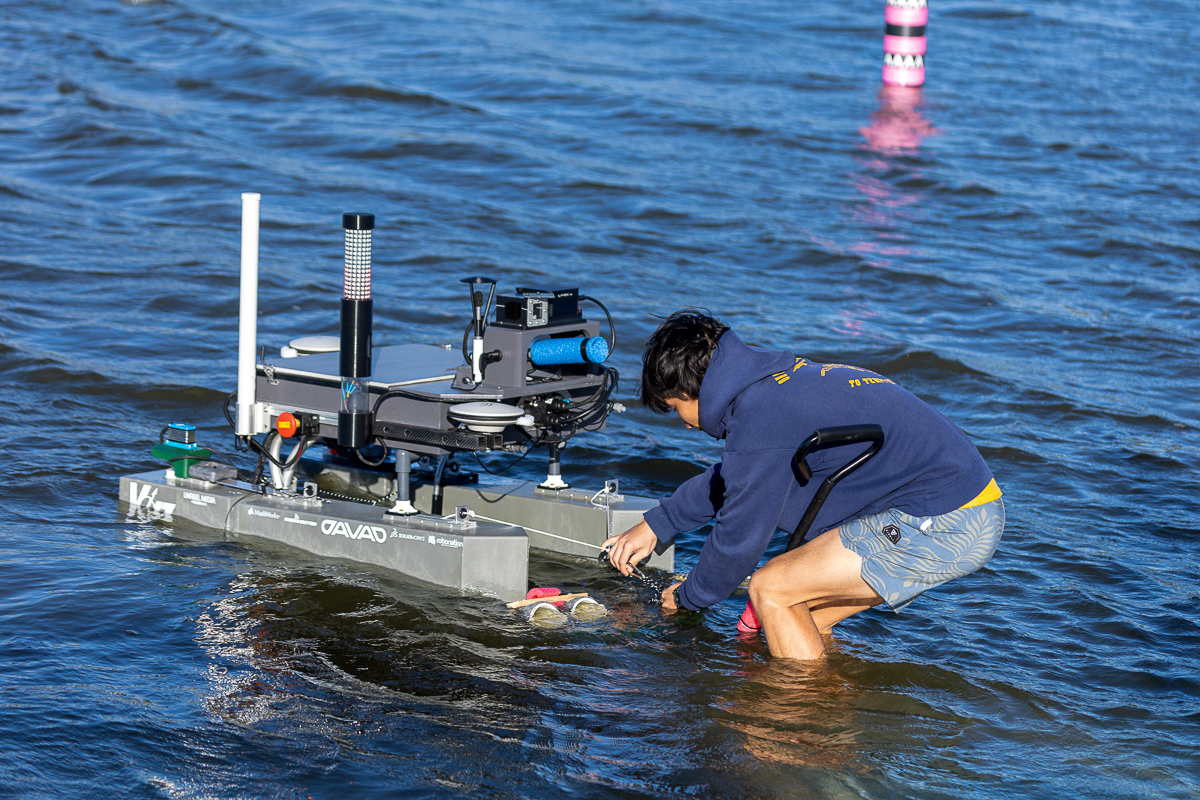 Man in water releasing robotic boat